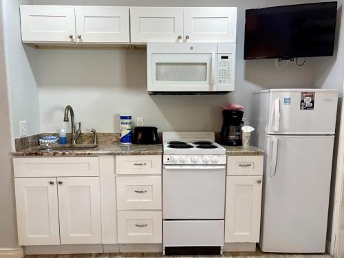 a kitchen with white cabinets and a white refrigerator at Beachgate Condo Suites and Hotel 218 condo in Port Aransas