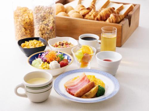 a table with breakfast foods and a box of bread at Hotel New Hankyu Osaka Annex in Osaka