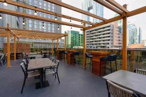 a restaurant with tables and chairs on a roof at The First Collection Marina, Dubai, a Tribute Portfolio Hotel in Dubai