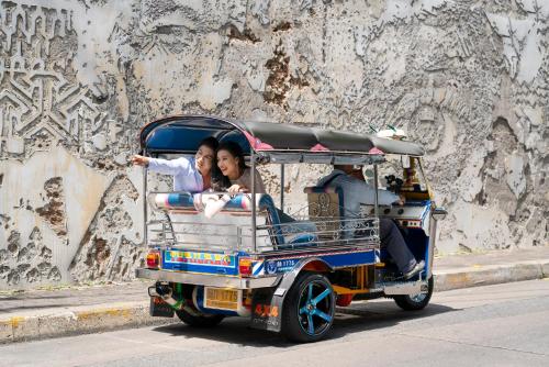 two people riding in a cart on a street at Bangkok Marriott Hotel The Surawongse in Bangkok