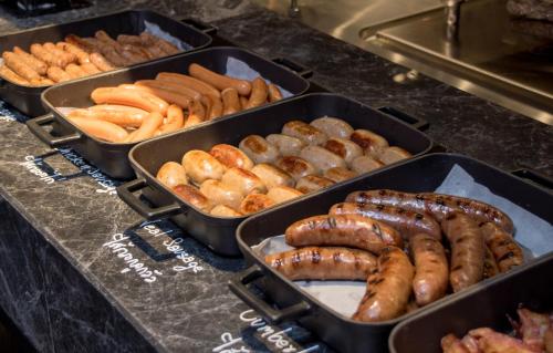a buffet with trays of hot dogs and sausages at Bangkok Marriott Hotel The Surawongse in Bangkok