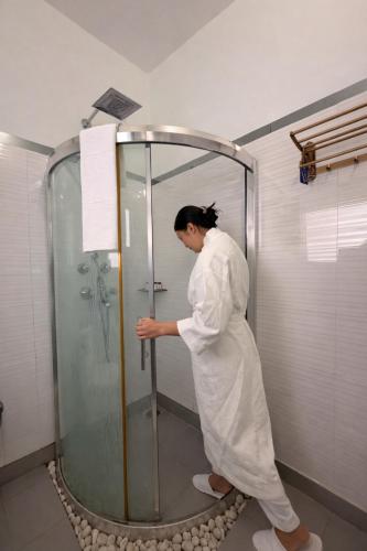 a woman standing in a shower in a bathroom at Sanskriti Vedic Retreat in Rishīkesh