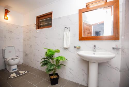 a bathroom with a sink and a toilet and a mirror at Cinnamon Legacy in Weligama
