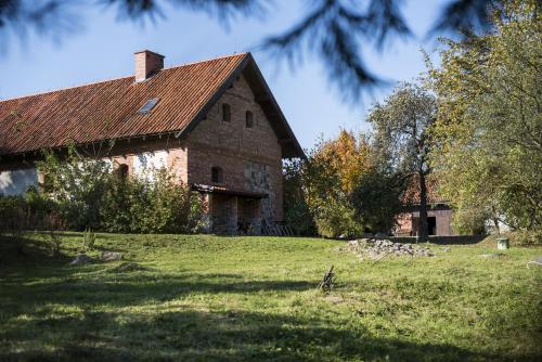 a large brick building in a grassy field at Siedlisko Błominko in Rzeck
