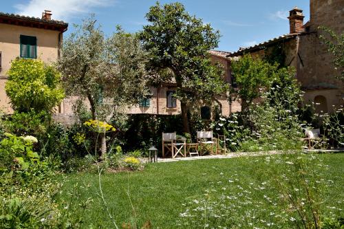 une maison ancienne avec un jardin en face dans l'établissement La Bandita Townhouse, à Pienza