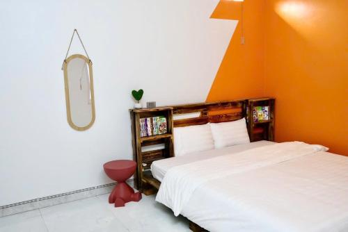 a bedroom with a white bed and an orange wall at Mocha Vila Mộc Châu in Mộc Châu