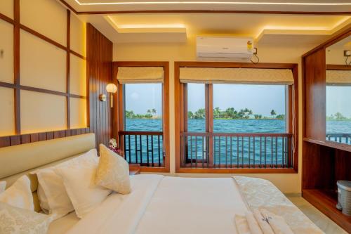 a bedroom with a bed and a balcony at My Trip Houseboats in Alleppey