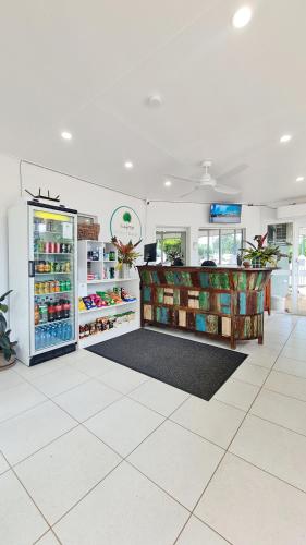 a grocery store with a refrigerator and shelves of food at Rainforest Motel, Mission Beach in Mission Beach