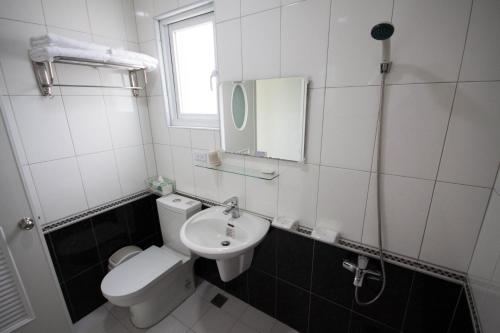 une salle de bain avec toilettes, lavabo et miroir dans l'établissement Sally's Home, à Hengchun Old Town