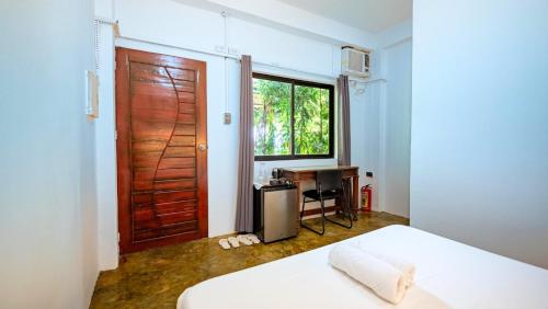 una camera da letto con un letto, una porta e una scrivania di Critter Republic Dive Resort a Dauin