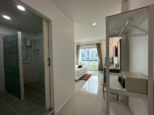 a bathroom with a shower and a sink and a mirror at Inn Dulgence in Patong Beach