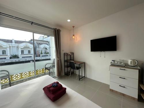 a bedroom with a bed and a flat screen tv at Inn Dulgence in Patong Beach