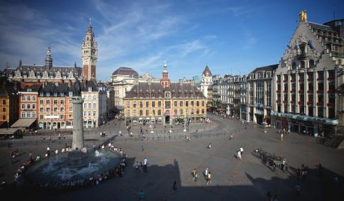 a city square with a clock tower and buildings at Hotel Carlton in Lille