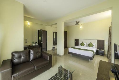 a hotel room with a bed and a couch at Daffodil Suites, Manyata Tech Park, Bengaluru in Bangalore