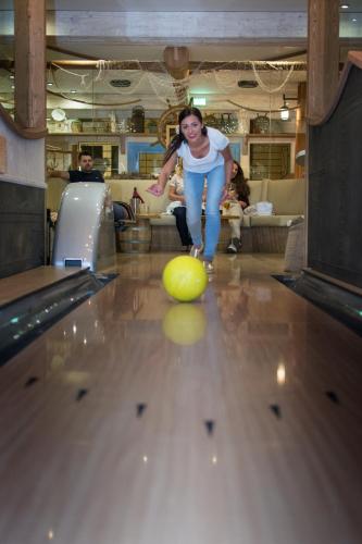 a young girl playing bowling in a bowling alley at Penzion Na Palubě in Jeseník