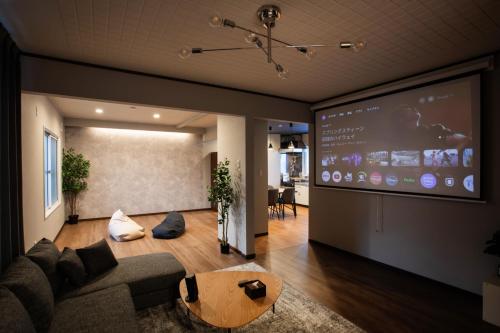a living room with a couch and a large screen at 禅ーZen Villa Hakodate in Hakodate