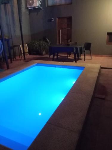 a swimming pool with blue lights in a living room at Espectacular casa centro laguna para parejas in Chascomús