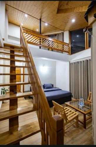 a bedroom with a bed and a staircase with at Manali Parvat View in Jagatsukh