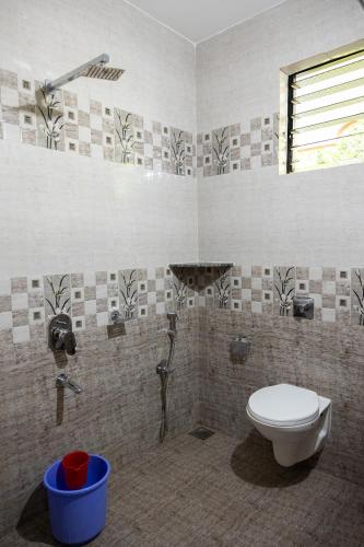 a bathroom with a toilet and a shower at Eve Resort in Patnem