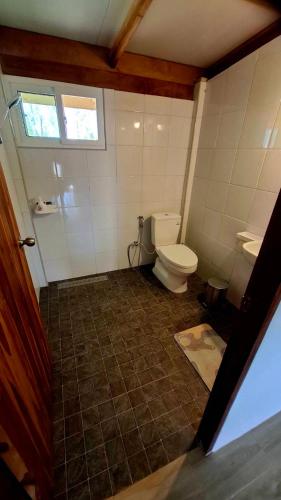 a bathroom with a toilet and a window at Anna Garden Homestay in Ban Phlu Kom