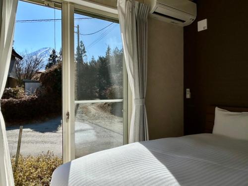 a bedroom with a bed and a large window at 71 Mt view - A棟 - in Fujikawaguchiko