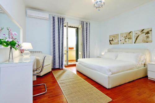 a white bedroom with a bed and a couch at Mecenate Charme Apartment in Rome