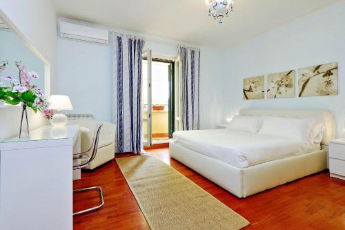 - une chambre blanche avec un lit et un canapé dans l'établissement Mecenate Charme Apartment, à Rome