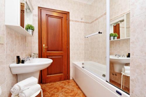 La salle de bains est pourvue d'un lavabo, d'une baignoire et de toilettes. dans l'établissement Mecenate Charme Apartment, à Rome