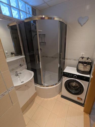 a bathroom with a shower and a washing machine at Summit Suite in Vysoké Tatry