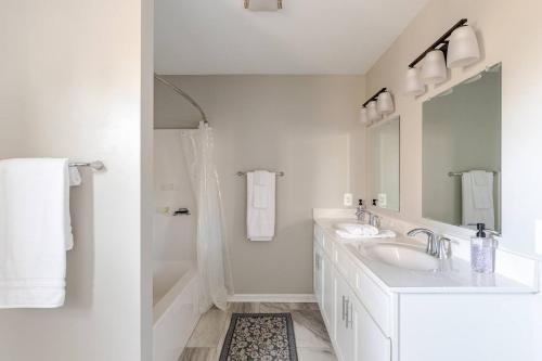 a white bathroom with two sinks and a shower at Litorum - a place to land, breathe, and reset in Front Royal