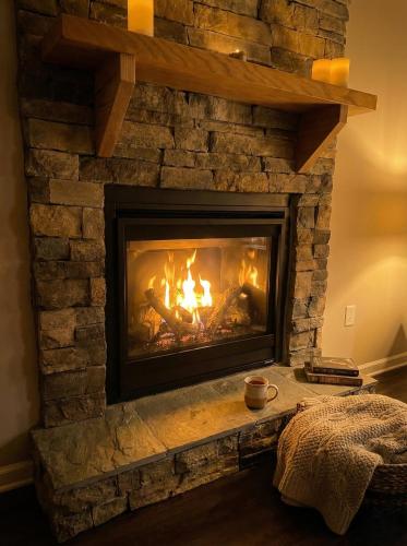 a brick fireplace with a fire in it at Litorum - a place to land, breathe, and reset in Front Royal