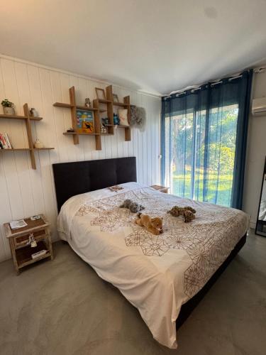 two stuffed animals sitting on a bed in a bedroom at Maison Nature in La Possession
