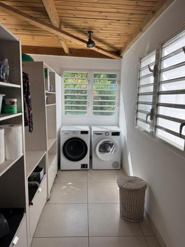 a laundry room with a washing machine and a washer at Maison Nature in La Possession