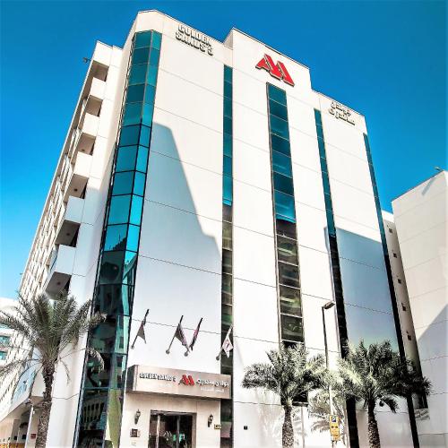 a tall white building with a sign on it at Golden Sands Bur Dubai in Dubai