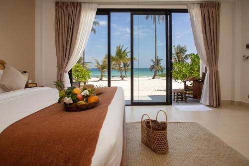 a bedroom with a bed with a view of the beach at Le Baoli Koh Rong in Phumĭ Kaôh Rŏng