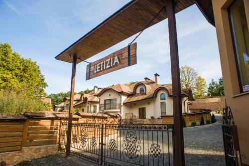 a gate with a sign in front of a house at LETIZIA country club in Shaian