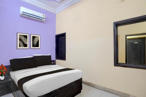 a bed in a room with purple walls at Hotel O Charbagh Metro Station Formerly Siddhi Paradise in Lucknow