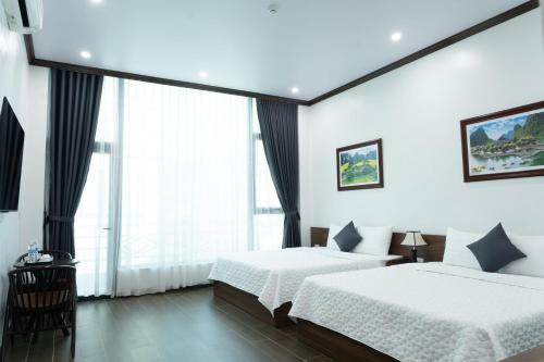a bedroom with two beds and a large window at Tamcoc Cloud Homestay in Ninh Binh