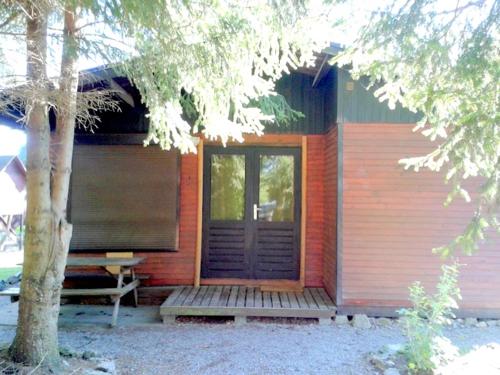 a small house with a porch and a bench in front of it at Chalet Sara in Resteigne