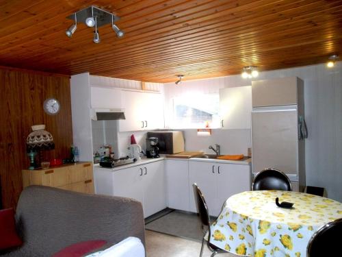 a kitchen with white cabinets and a table and a table and a tableablish at Chalet Sara in Resteigne