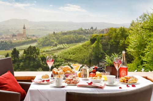 a table with food and drinks and a view of a valley at Schloss Hotel Korb in Appiano sulla Strada del Vino