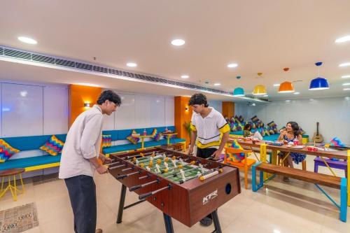 two men playing a game with a table in a room at goSTOPS Bengaluru, Jayanagar - Private Rooms & Dorms in Bangalore
