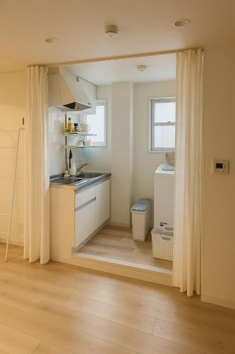 a kitchen with a sink and a counter top at 旅館ほのか in Osaka