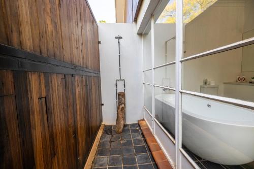 a bathroom with a bath tub and a sink at Archers Guest House in Patentie