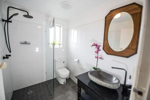 a bathroom with a sink and a toilet and a mirror at Jaspers Apartments in Brunswick Heads