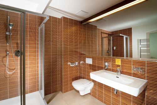 a bathroom with a toilet and a sink and a shower at Hotel Adam in Špindlerův Mlýn