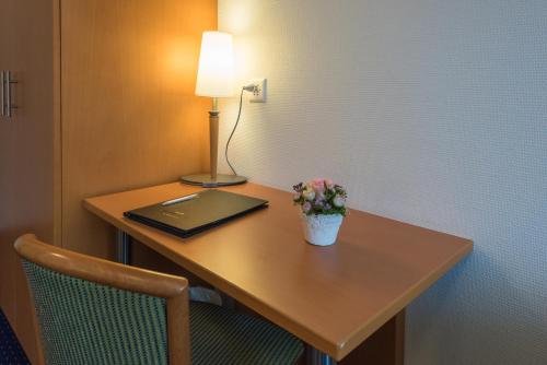 a desk with a laptop and a lamp on it at Parkhotel Gunten – Beach & Spa in Gunten