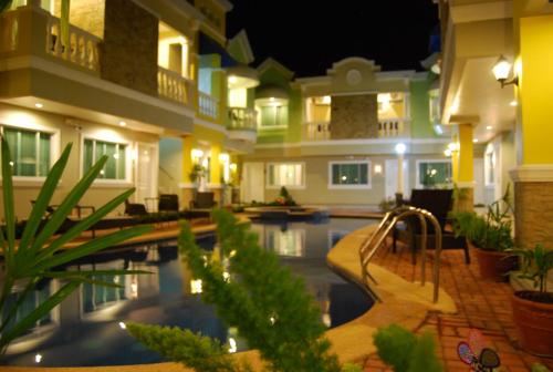 a hotel with a swimming pool at night at Prism Hotel in Angeles