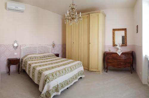 una camera con letto, cassettiera e specchio di Historical Apartments By Seaside a Viareggio