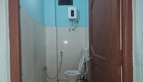 a bathroom with a toilet and a phone on the wall at Hotel Rani mahal Biratnagar in Biratnagar